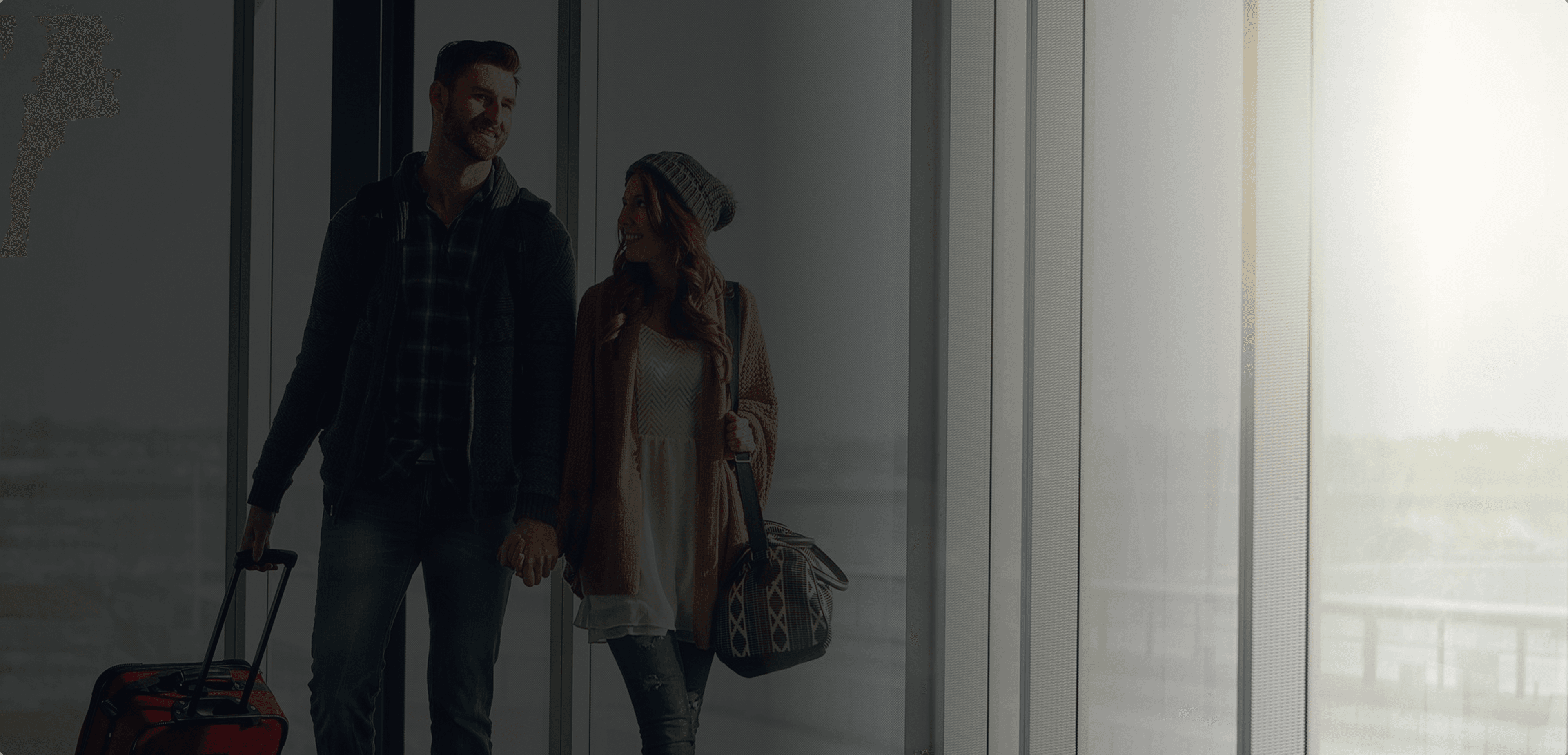Background image showing a happy couple in an airport